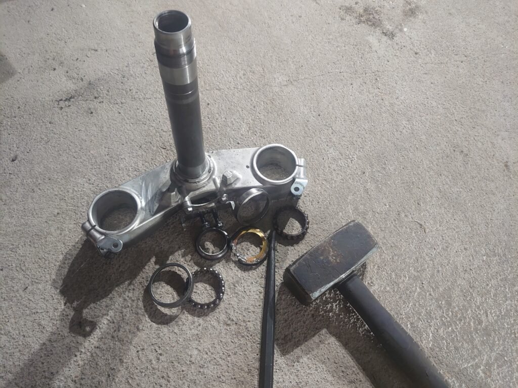 Disassembled steering stem and bearings – Kawasaki GTR 1400 undergoing steering bearing replacement.